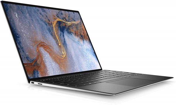 Photo of the Dell XPS 13 laptop with a thin bezel is shown open and angled slightly to the left, showcasing its large screen displaying a colorful abstract wallpaper. The keyboard is backlit, and there is a USB port visible on the side of the silver body.
