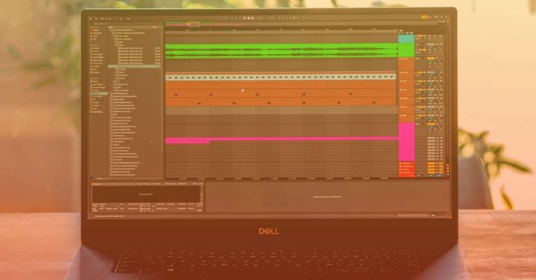 A Dell laptop running Ableton showcases various tracks and channels, featuring colored audio waveforms and effect controls on its screen. Positioned on a wooden surface, the scene is set against a blurred background.