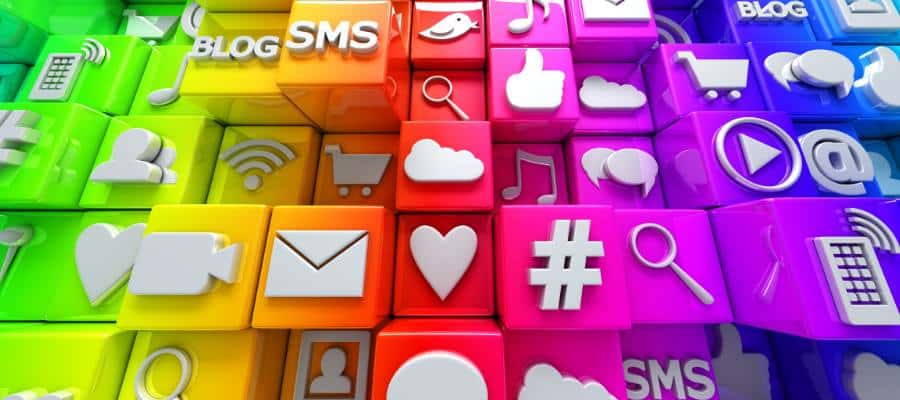 A colorful 3D grid of cubes featuring various app icons like mail, heart, hashtag, shopping cart, play button, and chat bubble. Each cube is in a different vibrant color, creating a visually diverse and engaging scene.